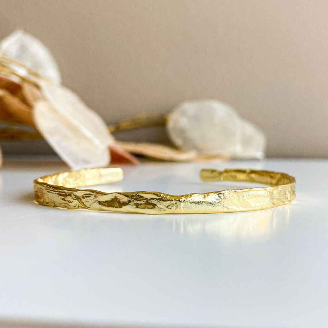 Close-up view of the intricate foil texture on the 18k gold-plated bangle, showcasing its craftsmanship.