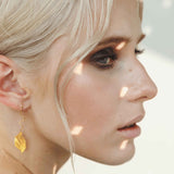 Close-up view of vintage-inspired leaf drop earrings in sterling silver, showcasing intricate craftsmanship.