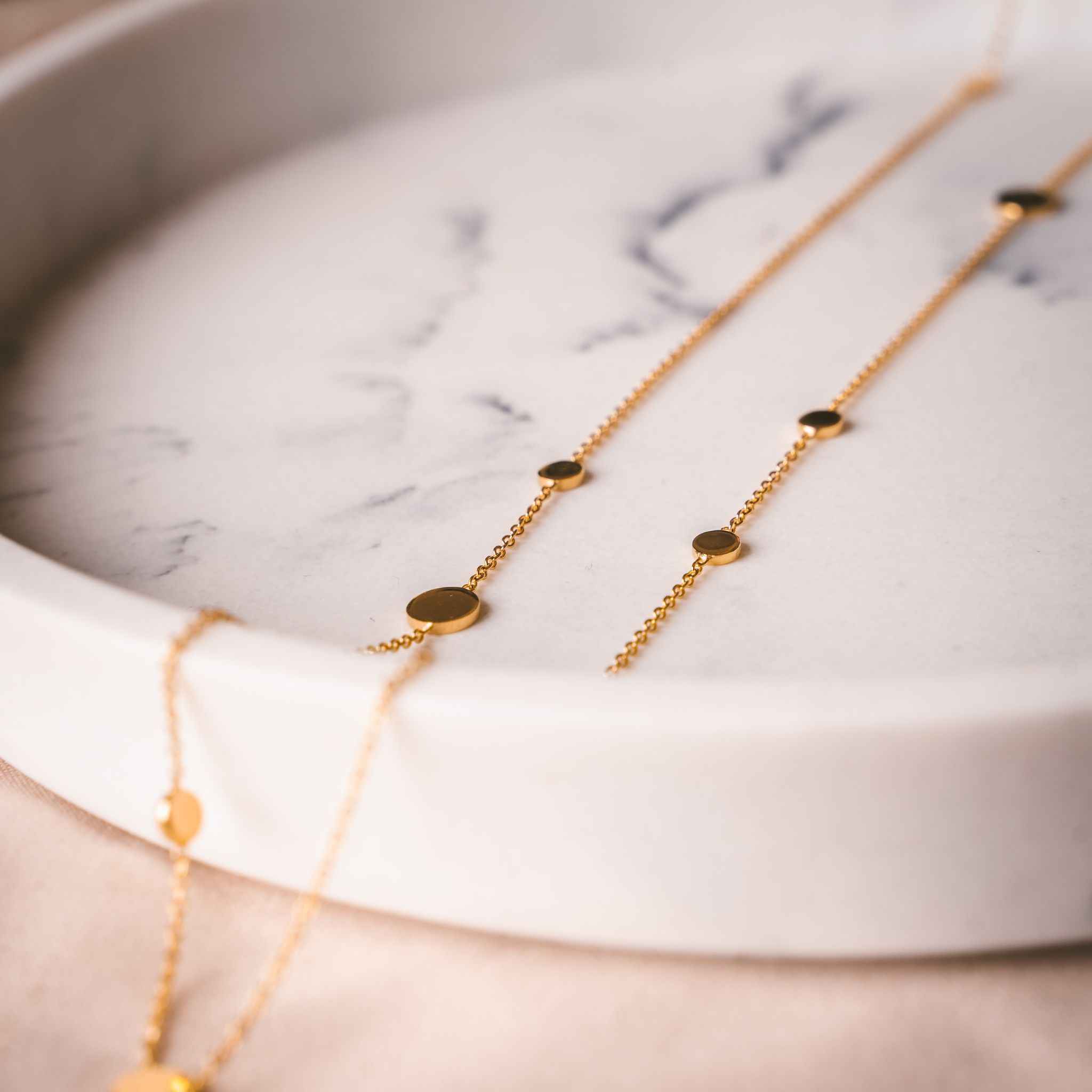 Close-up view of the dazzling Pebble Necklace in Gold, showcasing a minimalist design.