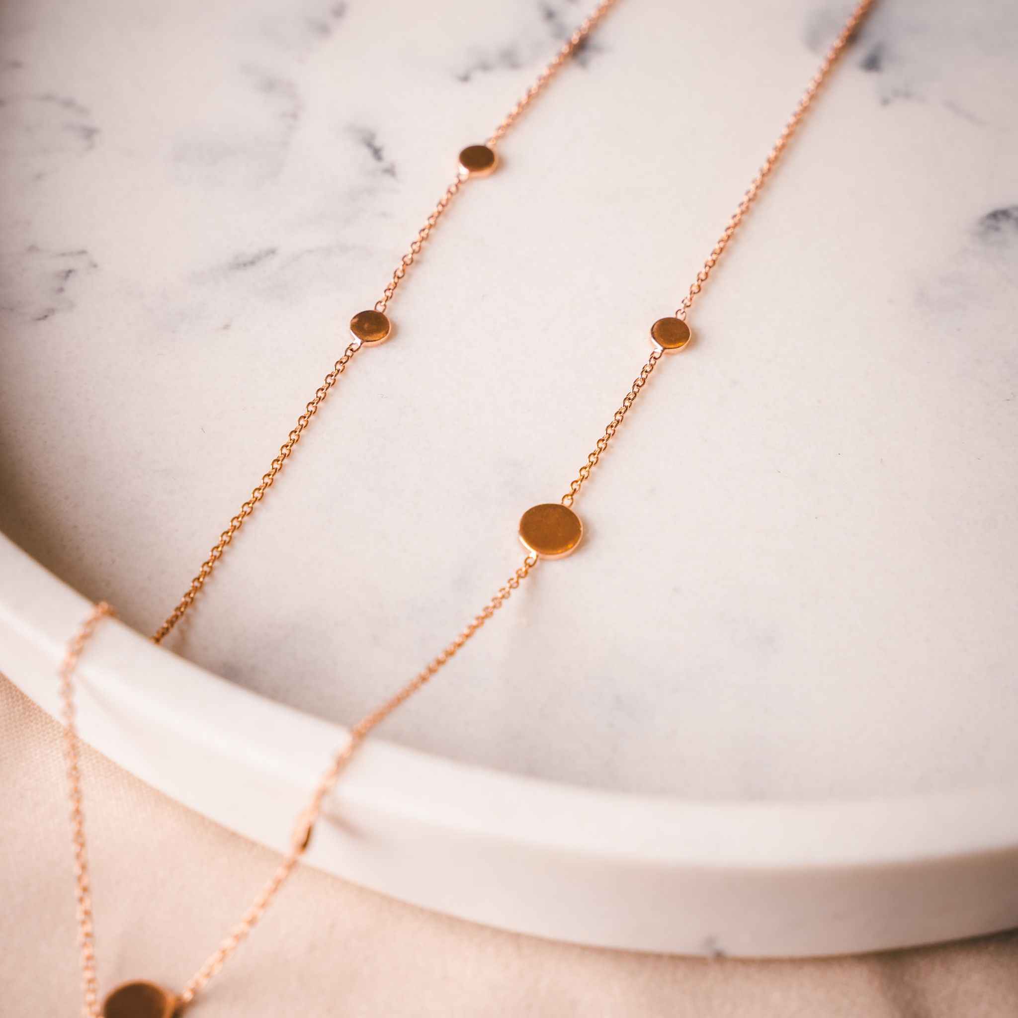 Close-up view of the dazzling Pebble Necklace in Rose Gold, showcasing a minimalist design.