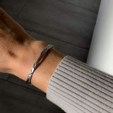 Closeup view of the timeless Silver Foil Textured Bangle worn on a woman's wist.
